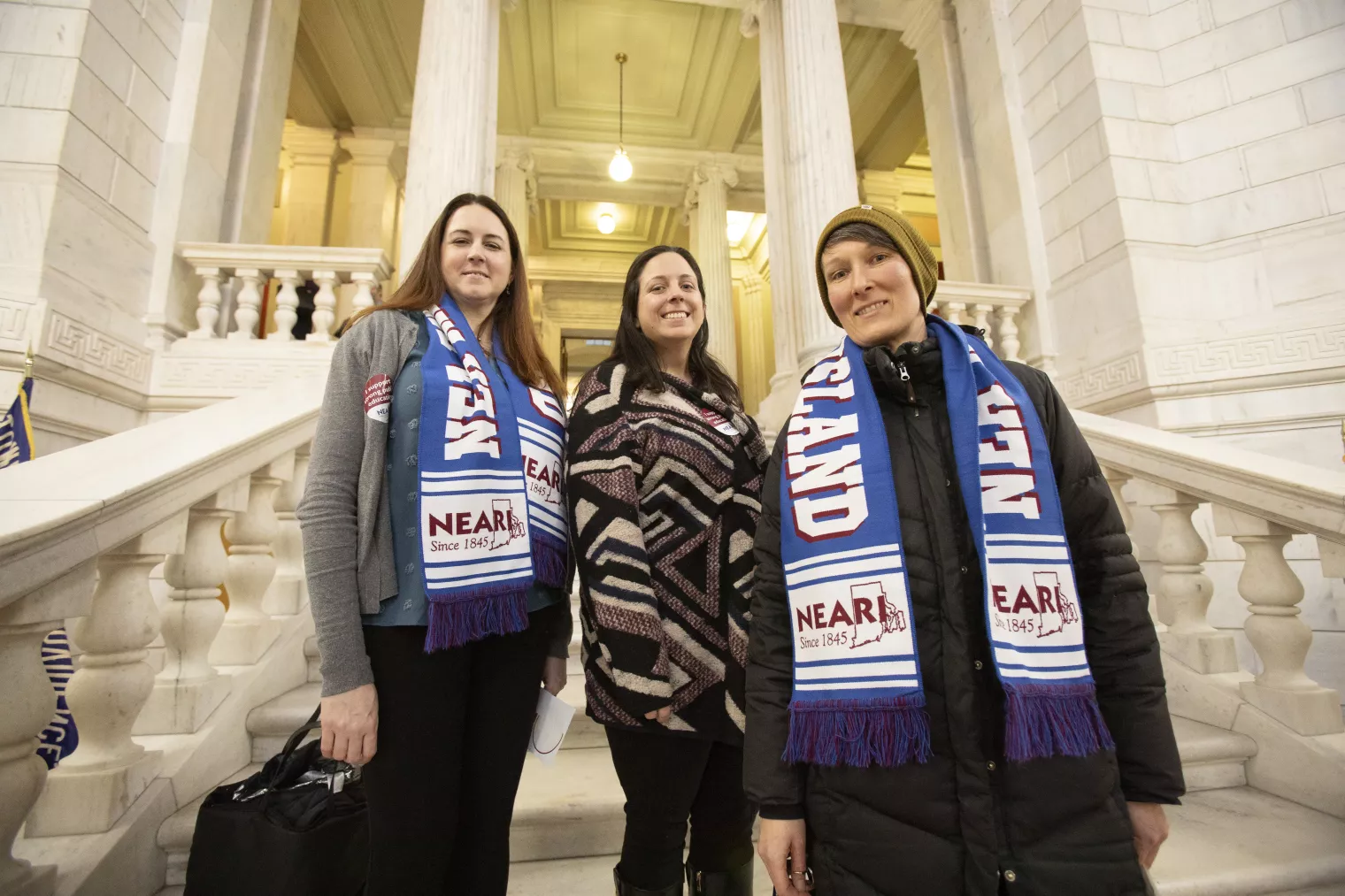 3 NEARI members on the steps inside the State House.