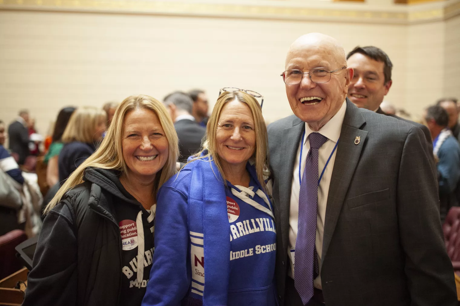 NEAR Members smile with a legislator on the floor at the State House on Lobby Day 2024.