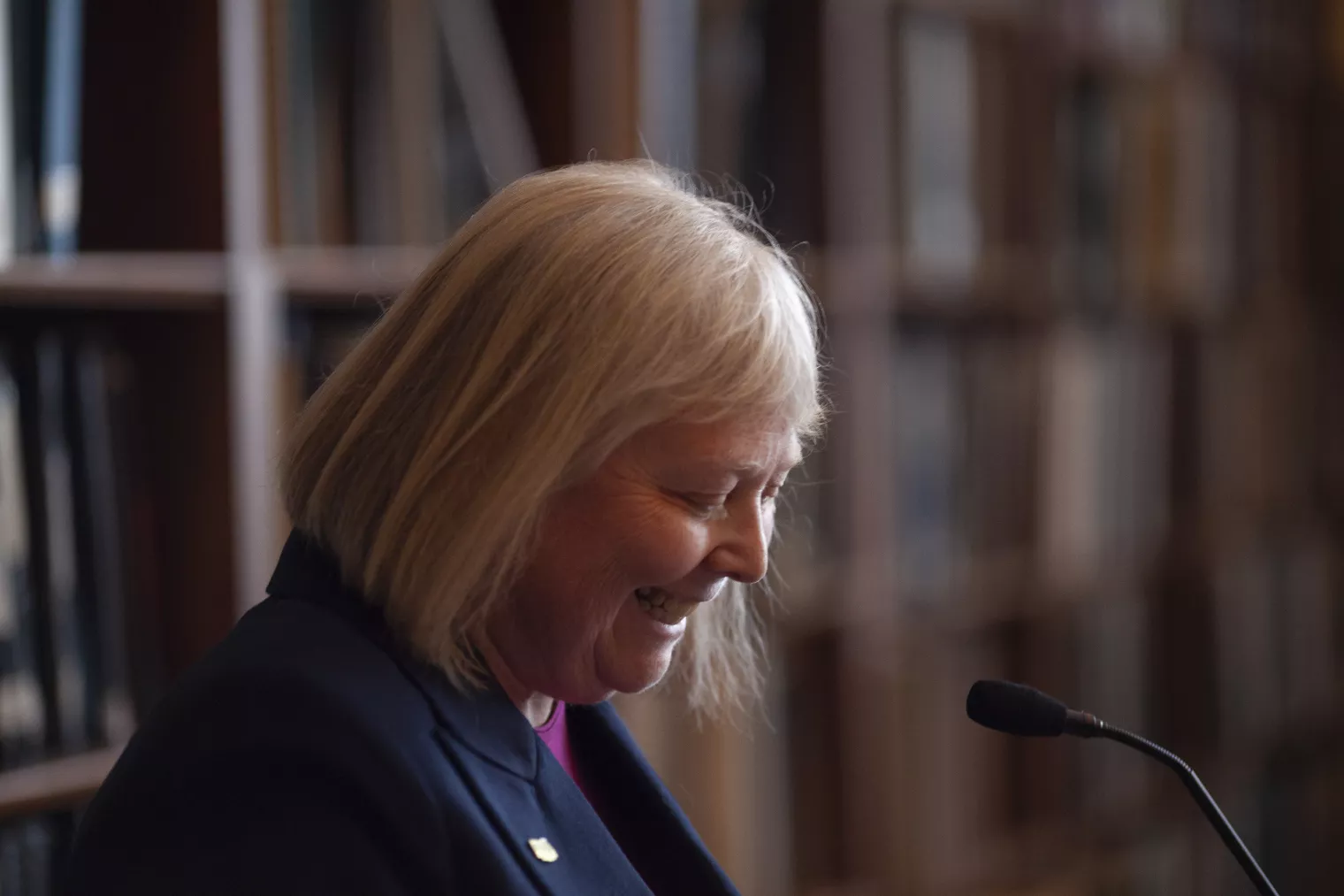 NEARI President Valarie Lawson smiling at a microphone while at a podium at Lobby Day 2024.