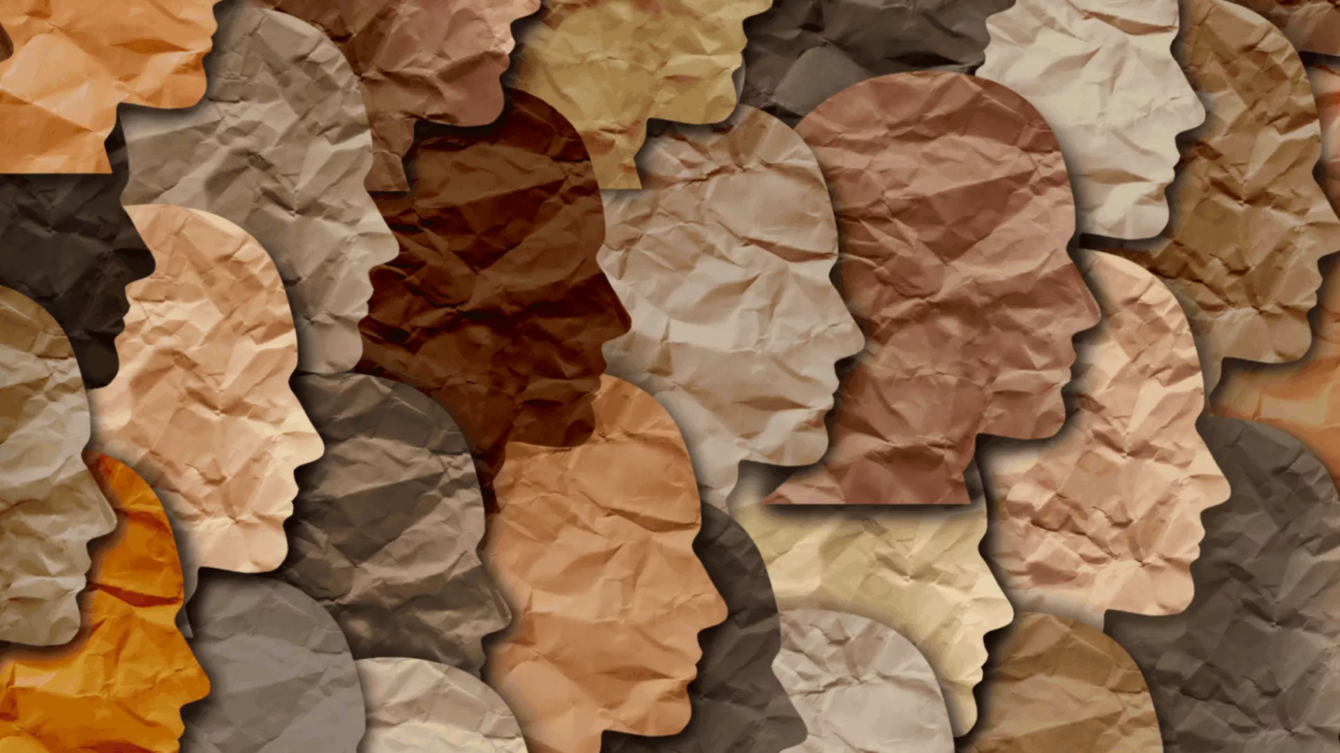 Paper faces in profile of many different races.