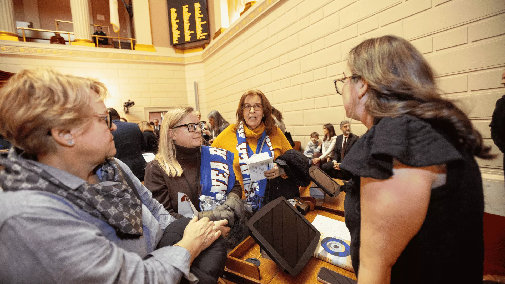 three women talking with a legislator on the House floor during 2024 Lobby Day