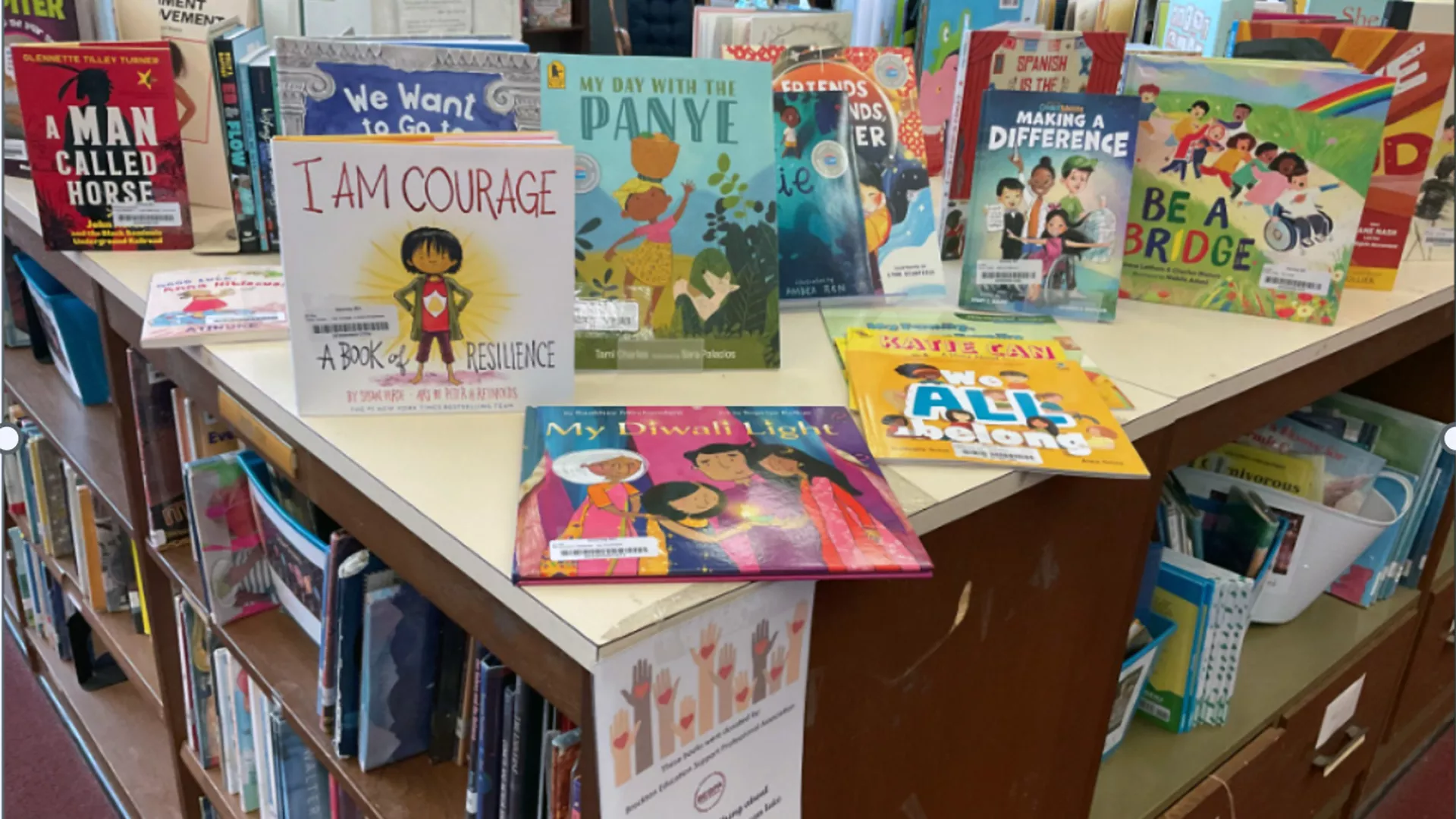 a school library bookshelf with several picture books displayed on top