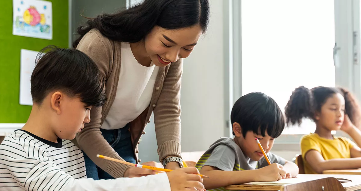 asian teacher working with students in class