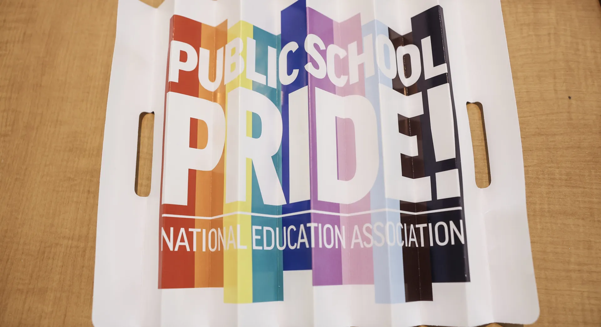 A sign displaying the words "Public School Pride" in bold letters against a colorful background.  