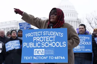 A woman addresses a crowd at a rally with the U.S. Capitol as a backdrop