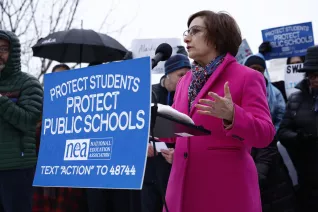 A woman addresses a crowd at a rally with the U.S. Capitol as a backdrop