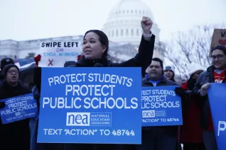 A woman addresses a crowd at a rally with the U.S. Capitol as a backdrop
