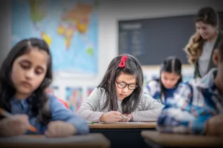 student working at classroom desk