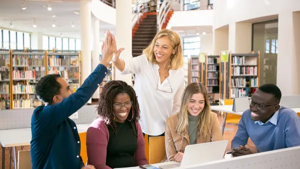 teacher high fives a student in the school library
