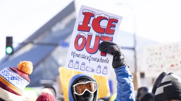 protester holding an ICE OUT sign