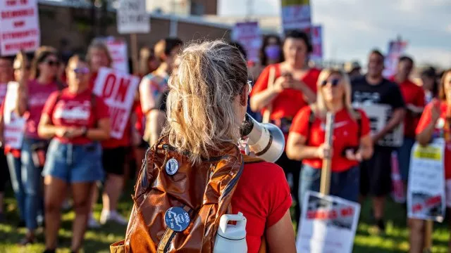 An educator at a rally with a bullhorn