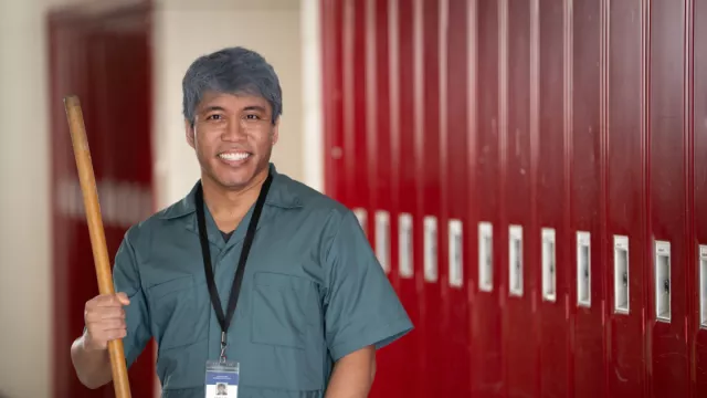 A custodian smiling in the hall.