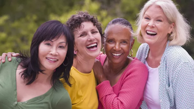 four retired women smile together for a picture
