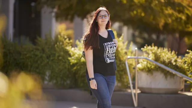 A student poses for a picture on a campus.