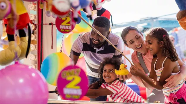 A family having fun at a fair game booth.