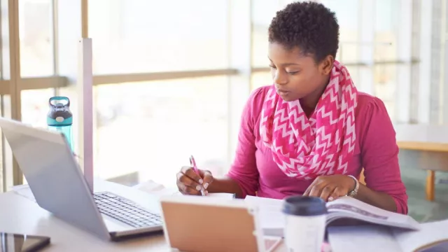 A woman studying on a laptop.