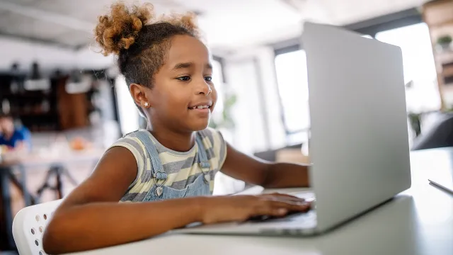 elementary age girl working on laptop
