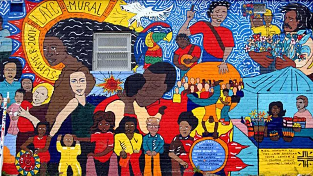 Colorful mural of several Hispanic people painted on a brick wall