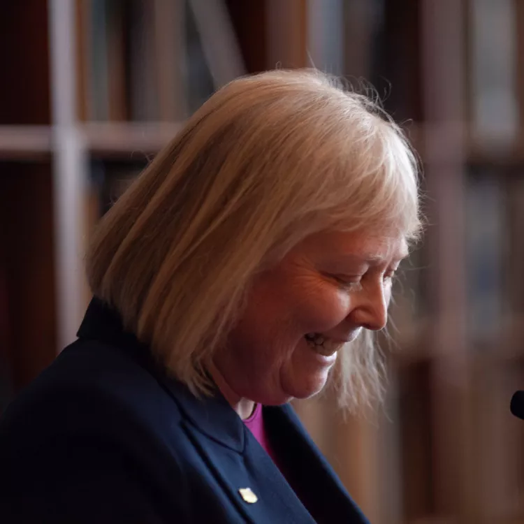 NEARI President Senator Val Lawson looks at her notes and smiles while speaking at the 2024 NEARI Lobby Day.